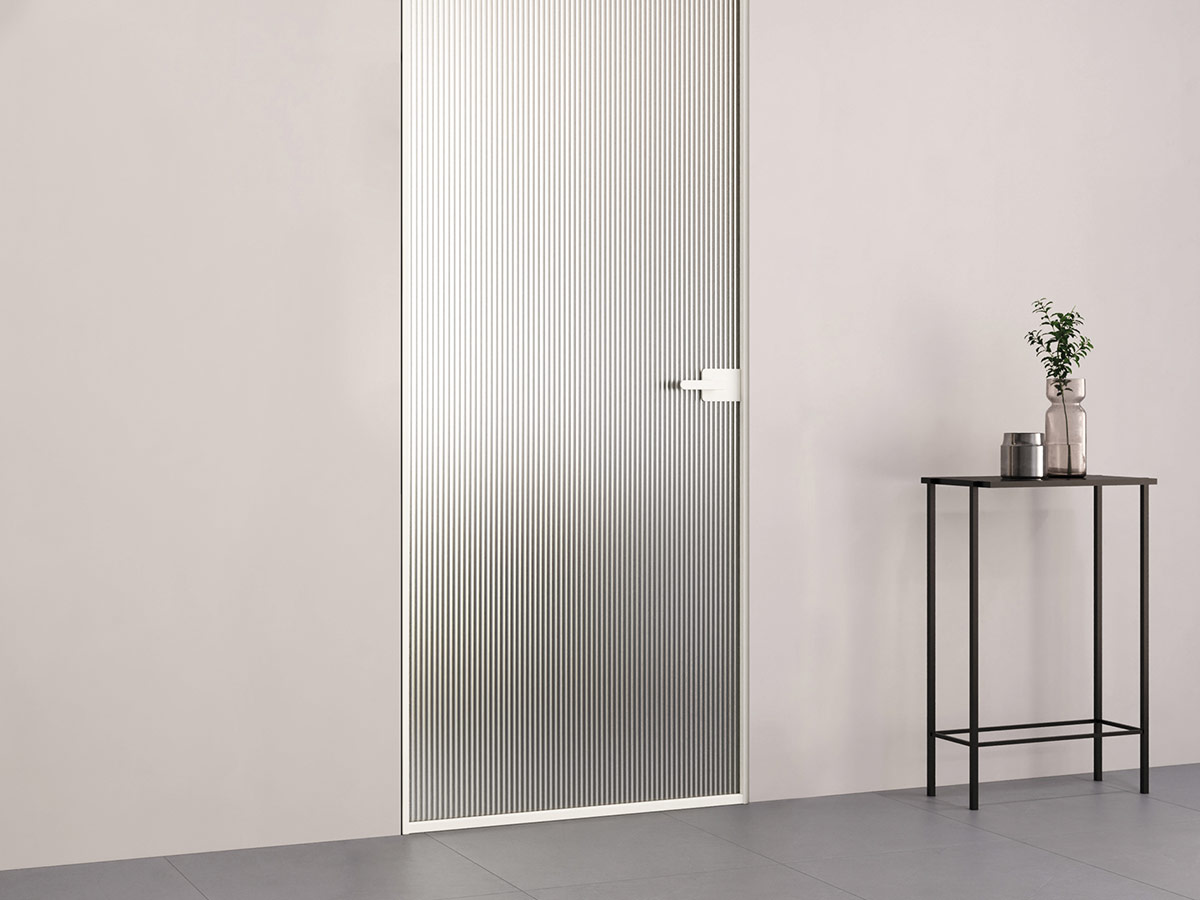 puerta en vidrio acanalado en una sala con suleo en marmol gris